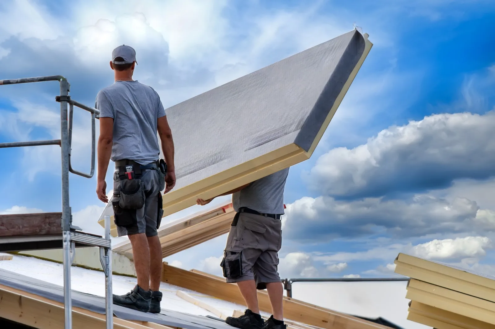 Dachdecker bringen Dammplatten auf ein Dach fuer eine energetische Sanierung